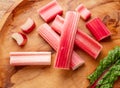 Cuts of red rhubarb stem on wooden plate on the table, top view Royalty Free Stock Photo