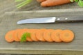 Cuts slices of fresh carrot and knife on wooden rustic Royalty Free Stock Photo