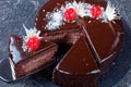 Cutted chocolate cake with cherries on top
