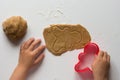 Cutted form of man on rolled out gingerbread dough made by child on white background