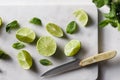 Cutted fresh lime on white marble kitchen board with mint.