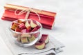 Cutted rhubarb in glass dish, whole sticks on background, horizontal, copy space