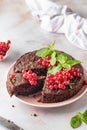 Cutted Tasty homemade chocolate cake brownie decorated with red currant berries and mint on white marble table Royalty Free Stock Photo