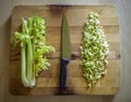 Cutted and whole celery on a wooden board with a knife