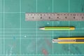 Cutter , wood pencil and ruler on old green rubber pad background Royalty Free Stock Photo