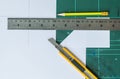 Cutter , wood pencil and ruler on old green rubber pad background Royalty Free Stock Photo