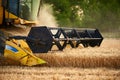 Cutting bar unit or reaper machine cuts stems. Combine harvester working in wheat field. Harvesting machine driver Royalty Free Stock Photo