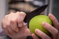 Cutting a big round green apple Royalty Free Stock Photo