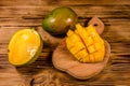 Cutting board with chopped mango fruit on a wooden table