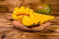 Cutting board with chopped mango fruit on a wooden table