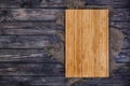 Cutting board on dark wood background, top view Royalty Free Stock Photo