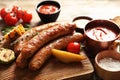 Cutting board with delicious barbecued sausages served Royalty Free Stock Photo