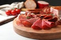 Cutting board with different meat delicacies on gray table Royalty Free Stock Photo