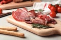 Cutting board with different meat delicacies on table Royalty Free Stock Photo