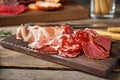 Cutting board with different meat delicacies on wooden table Royalty Free Stock Photo