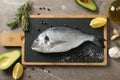 Cutting board with Dorado fish and cooking ingredients on background, top view Royalty Free Stock Photo