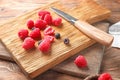 Cutting board with fresh ripe raspberries on wooden table Royalty Free Stock Photo