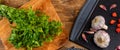 Cutting board with garlic, beak pepper and parsley on wood