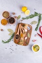 Cutting board with herbs and spices - rosemary, garlic, salt, pepper, olive oil, lemon. Culinary background. Royalty Free Stock Photo