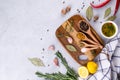 Cutting board with herbs and spices - rosemary, garlic, salt, pepper, olive oil, lemon. Culinary background. Royalty Free Stock Photo