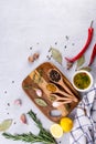 Cutting board with herbs and spices - rosemary, garlic, salt, pepper, olive oil, lemon. Culinary background. Royalty Free Stock Photo