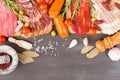 Cutting board with jamon, prosciutto, bacon, salami and chorizo on dark wooden background. From top view.