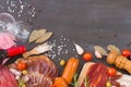 Cutting board with jamon, prosciutto, bacon, salami, chorizo and red wine on dark wooden background. From top view.