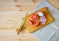 Cutting board, knife and cutted  tomato and purple onion on wooden background Royalty Free Stock Photo