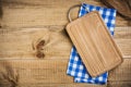 Cutting board over blue kitchen towel on wooden texture background Royalty Free Stock Photo