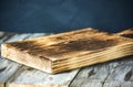 Cutting board over towel on wooden kitchen table.