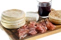 Cutting board with small round flat bread, ham, cheese and glass of red wine Royalty Free Stock Photo