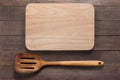 Cutting board and spatula on the wooden background