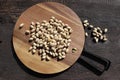 Cutting board with tasty pistachio nuts on dark rustic brown wooden background