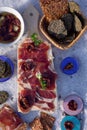 A cutting board  with  Traditional  tapas    with  spanish cured meat, bread chips with seed,  sun dried tomato with   garlic, Royalty Free Stock Photo