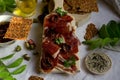 A cutting board  with  Traditional  tapas    with  spanish cured meat, sun dried tomato , parsley and bread chips with seed,  dry Royalty Free Stock Photo