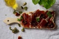 A cutting board  with  Traditional  tapas    with  spanish cured meat, sun dried tomato , parsley, dry red and green pepper, Royalty Free Stock Photo