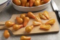 Cutting board with yellow whole and halved pear tomatoes close up Royalty Free Stock Photo