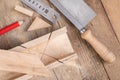 Cutting boards with a handsaw at an angle in the template. Minor carpentry work in the workshop. Royalty Free Stock Photo