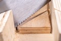 Cutting boards with a handsaw at an angle in the template. Minor carpentry work in the workshop. Royalty Free Stock Photo