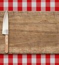 Cutting breadboard and kitchen knife. Cooking set over red gingham tablecloth. Royalty Free Stock Photo