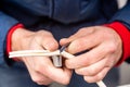 Cutting cable insulation with a segmented knife. White cable, yellow knife. Close-up. Horizontal orientation.