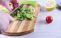 Cutting celery on cutting board with cherry tomato and lemon