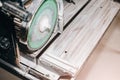 Cutting a ceramic tile on a special electric wet water cutter saw machine. Maintenance repair in the flat. Renovation process Royalty Free Stock Photo