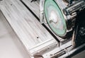 Cutting a ceramic tile on a special electric wet water cutter saw machine. Maintenance repair in the flat. Renovation process Royalty Free Stock Photo