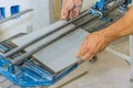 Cutting ceramic tile with tile cutting hand machine is performed by a construction worker. Royalty Free Stock Photo