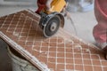 A worker places a large ceramic tile in a cutting machine Royalty Free Stock Photo