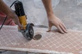 Cutting ceramic tiles. A worker places a large tile in a machine Royalty Free Stock Photo