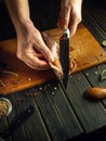 Cutting fresh fish with a knife in the hands of a chef on the kitchen table. Low key concept of preparing fish dish in pub kitchen Royalty Free Stock Photo