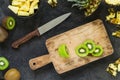 Cutting fresh kiwi and pineapple on wooden board. Top view Royalty Free Stock Photo