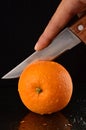 Cutting a fresh orange with knife